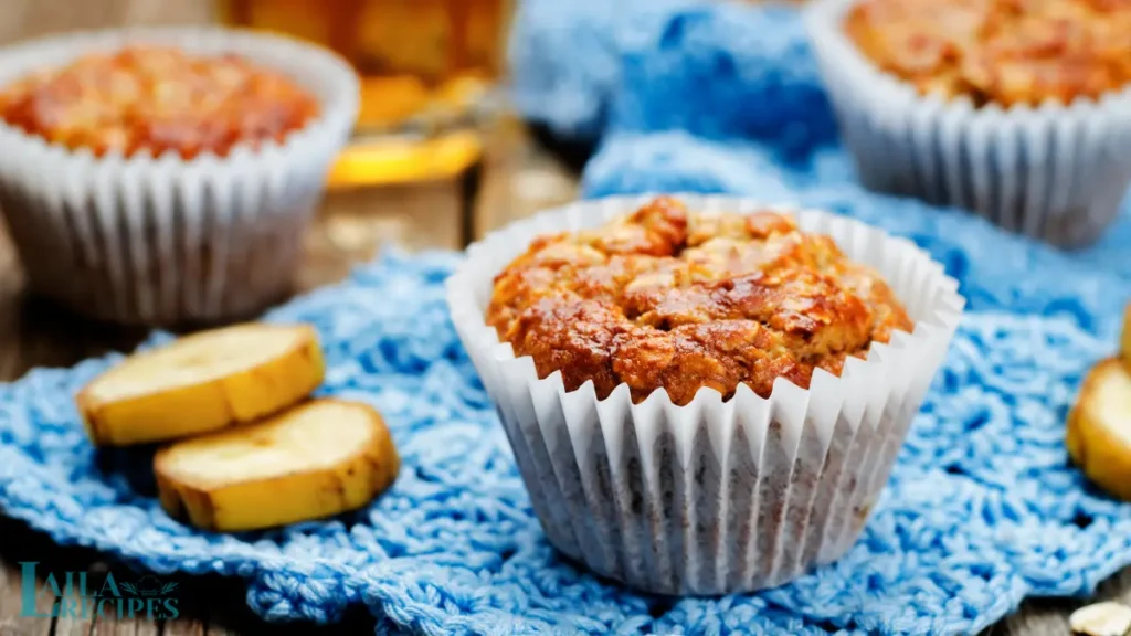 Close-up of a moist banana oat muffin with visible oats and chocolate chips.