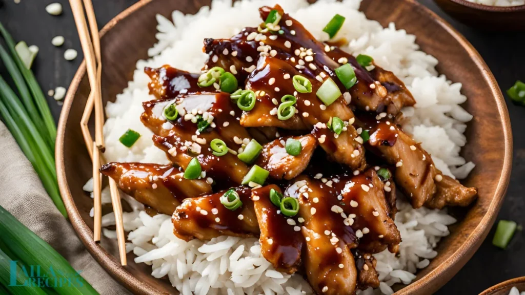 Sliced chicken breast and green onion on a cutting board